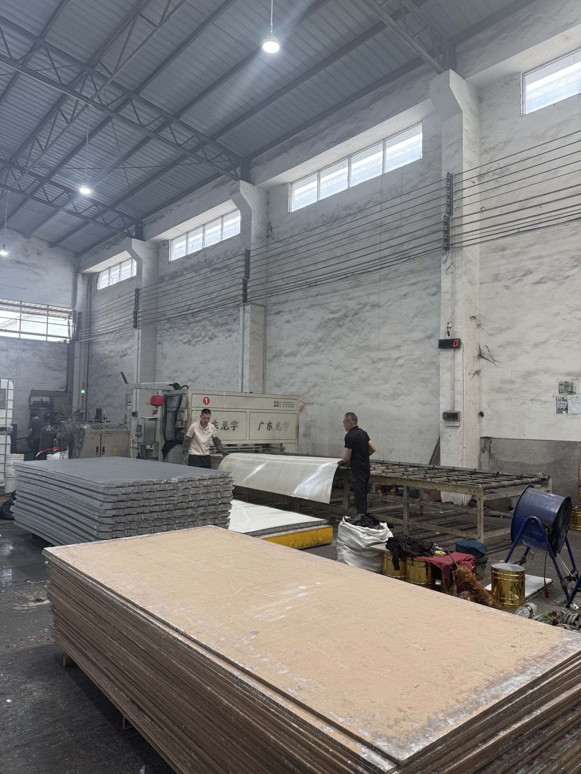 Aluminum honeycomb panel manufacturing workshop with production equipment and stacked panels